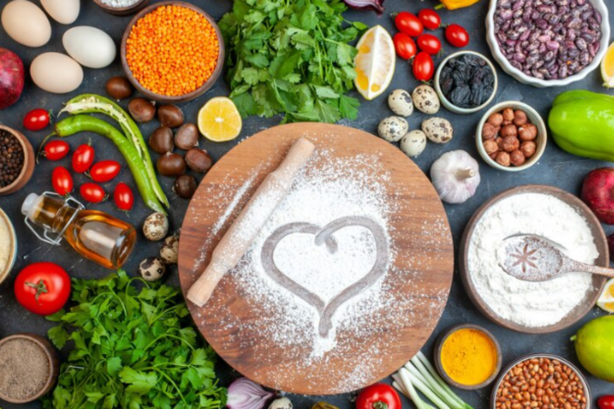 A close-up photo of a heart-shaped symbol made of flour on a wooden cutting board.

